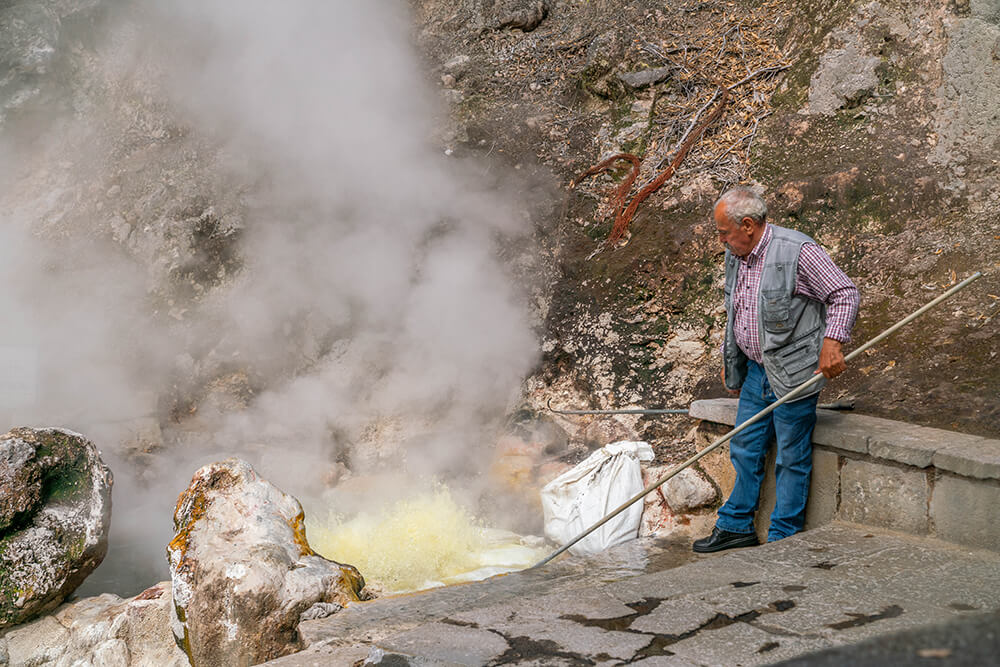 Furnas on Sao Miguel Azores. A man cooking corn in a caldeira