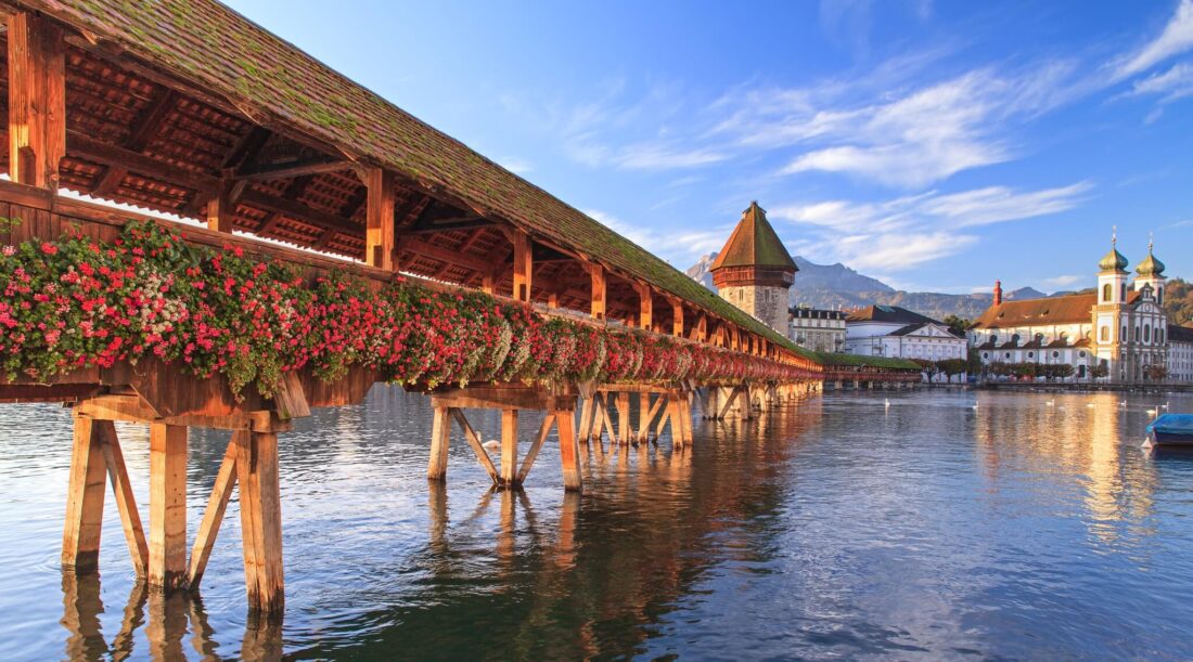 A flower covered bridge over the water in Lucerne Switzerland