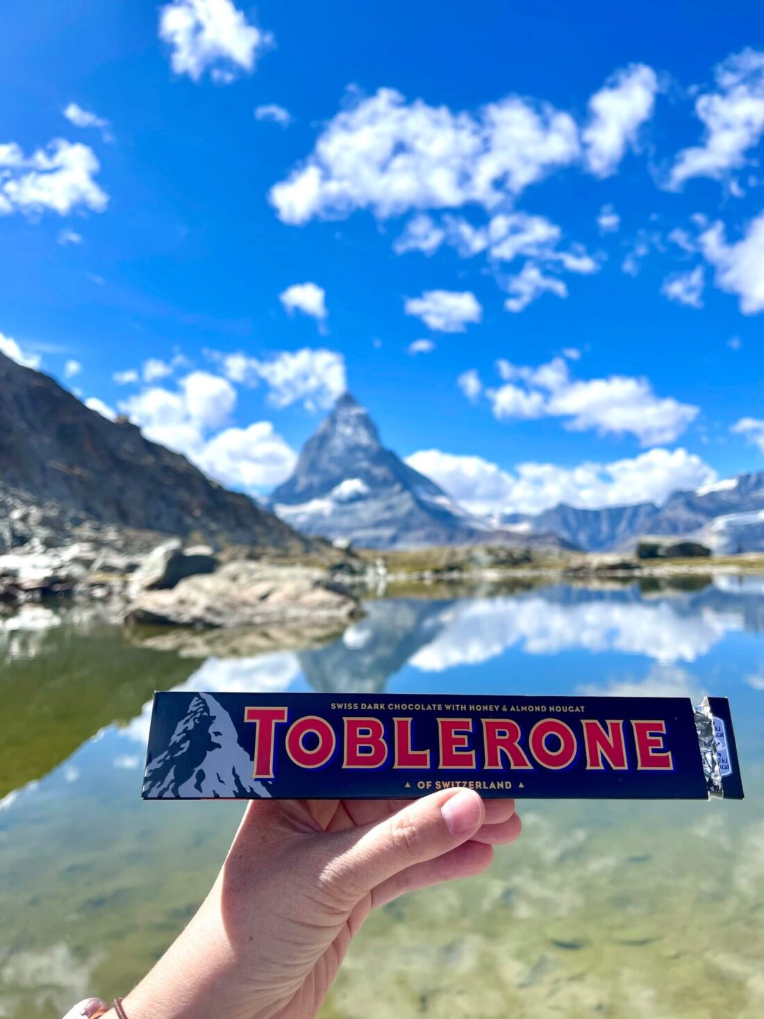 Toblerone chocolate bar being held up with the Matterhorn in the background